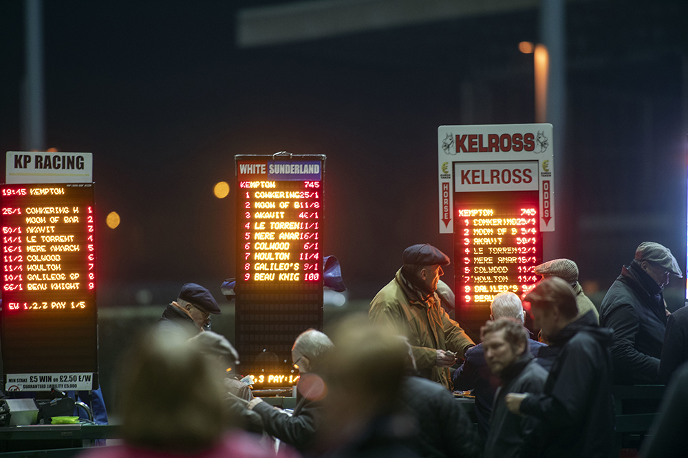 Spectators bet at Kempton Park Racecourse, Esher.